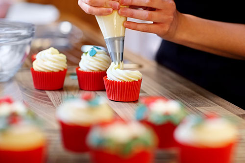 cupcakes being decorated by hands