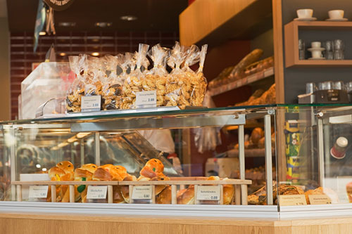 a bakery shop counter with an assortment of pastries